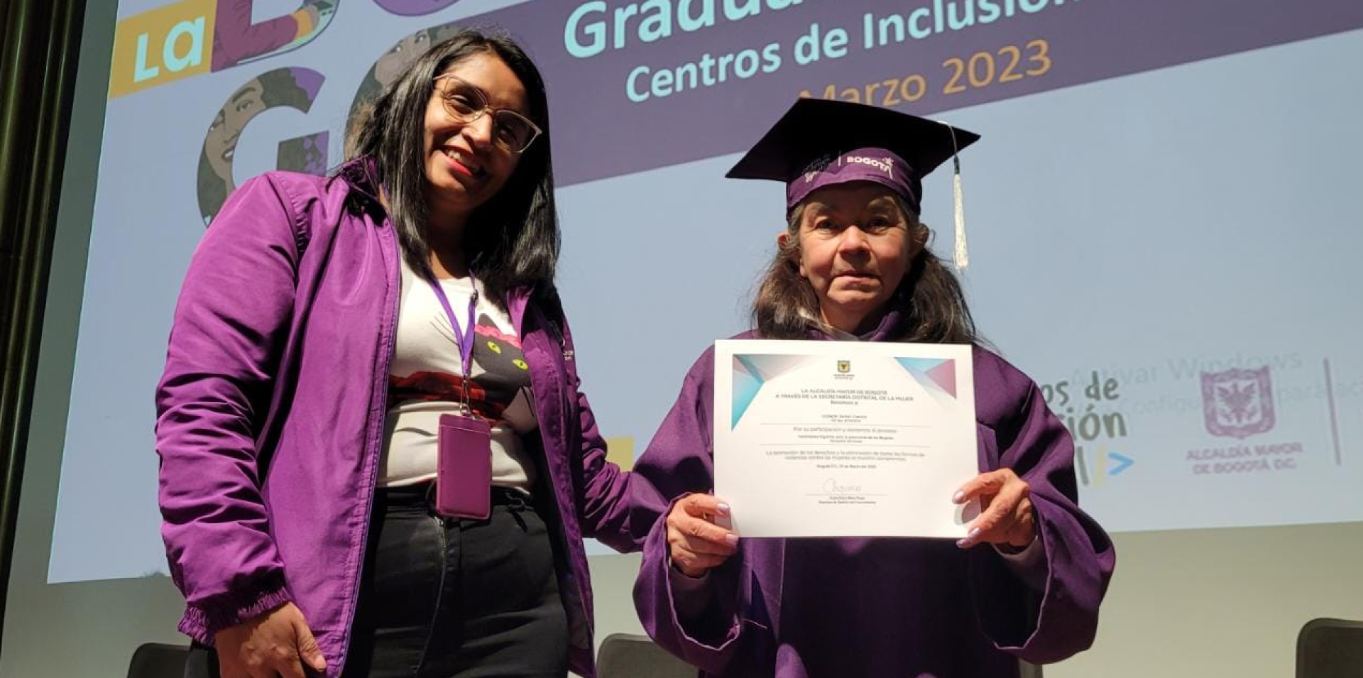 Mujer mayor con toga y birrete en ceremonia de graduación de centros de inclusión digital