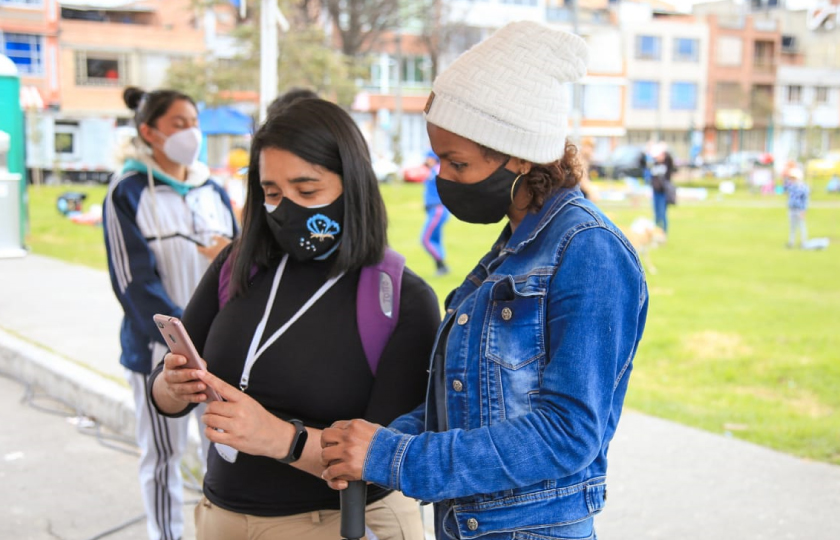 Imagen de dos mujeres mirando un celular y hablando