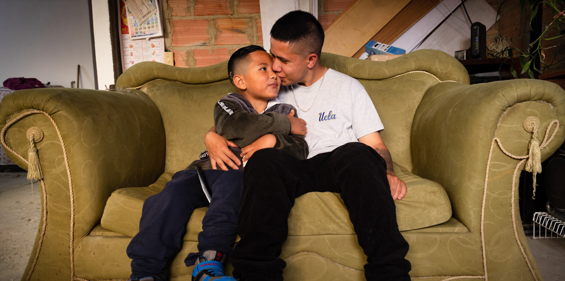 Hermanos felices en mueble de la sala de su casa