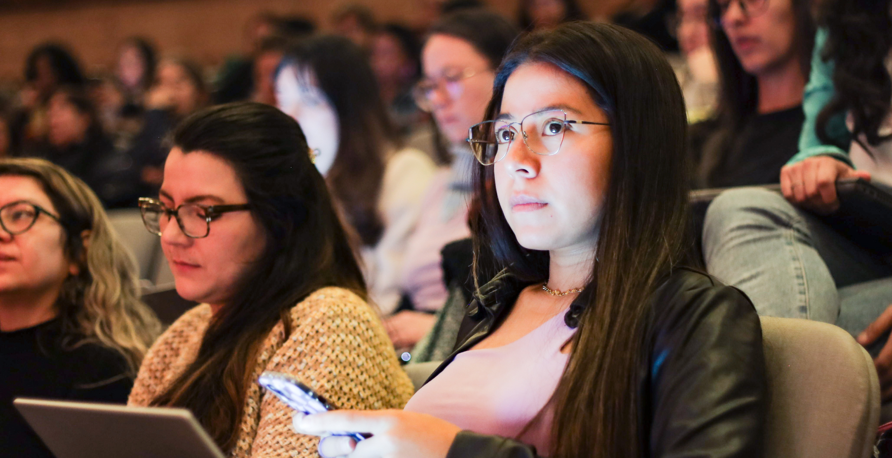 Mujeres tomando curso presencial con su celular