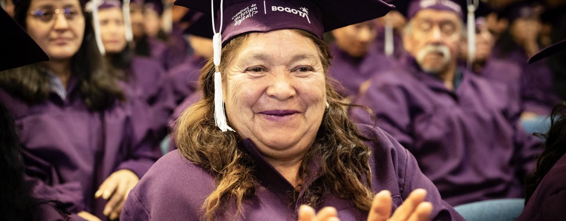 Mujer graduanda del Sistema Distrital del Cuidado aplaude 