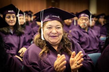 Mujer graduanda del Sistema Distrital del Cuidado aplaude 