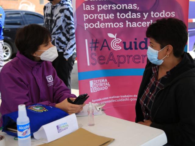 Imagen de funcionaria de la secretaría de las mujer y otras mujer hablando